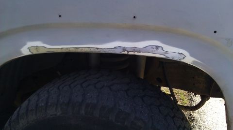 1984 Ford Bronco - Body filler is applied to the rusted area of the wheel well.