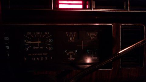 1984 Ford Bronco - Dashboard gauges of a 1984 Ford Bronco, including tachometer, fuel, temperature, and charge indicators.