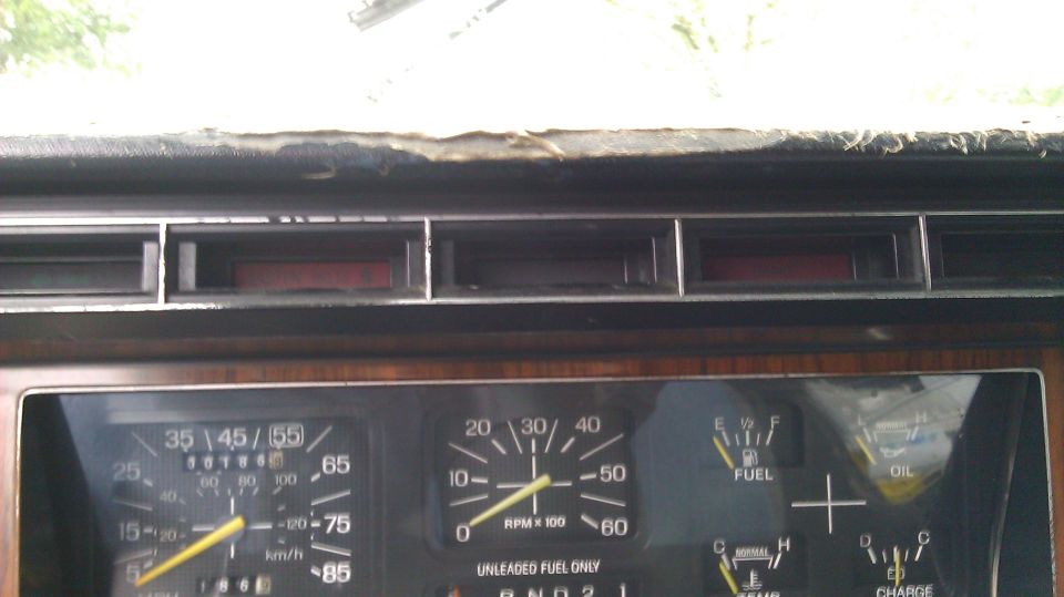 1984 Ford Bronco dashboard with wood grain trim, speedometer, tachometer, fuel, and oil gauges