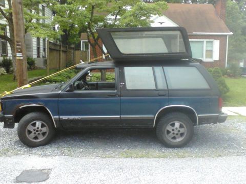 1988 Ford Bronco - This SUV has a two-tone paint scheme and a camper top that is open.
