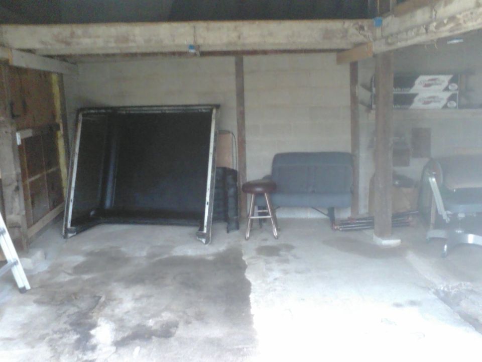 Truck cap in garage with a stool and bench
