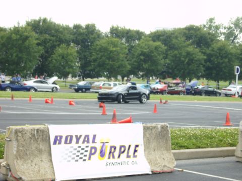 2007 Ford Mustang - A black 2007 Ford Mustang navigates a course marked by orange cones, with other vehicles visible.