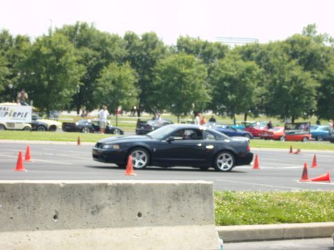 2007 Ford Mustang - A black coupe navigates a course marked by orange cones during an event.
