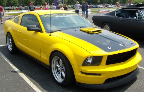 2007 Ford Mustang - A yellow Mustang with custom decals on the windshield is parked at an outdoor event.