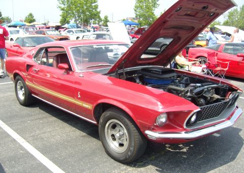 2007 Ford Mustang - A classic red Ford Mustang Mach 1 is displayed with its hood open, revealing the engine bay.