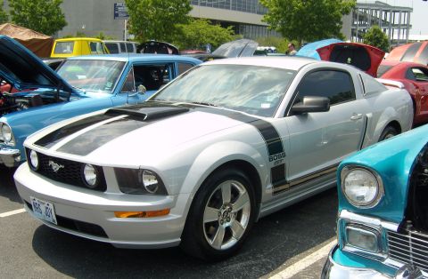 2007 Ford Mustang - A silver 2007 Ford Mustang Boss 302 is parked among other vehicles at an outdoor car show.