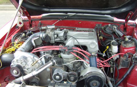 2007 Ford Mustang - Close-up view of a modified engine bay, a supercharger and various engine components.