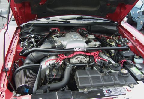 2007 Ford Mustang - Engine bay of a 2007 Ford Mustang, showing the V8 engine and various aftermarket components.