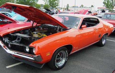 2007 Ford Mustang - A bright orange 1970 Ford Torino GT is displayed with its hood open, revealing the engine bay.