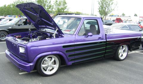 2007 Ford Mustang - Customized pickup truck with hood open, parked at an outdoor event. Features flame graphics and chrome wheels.