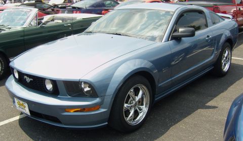 2007 Ford Mustang - A blue 2007 Ford Mustang GT is parked in a lot with other vehicles visible.
