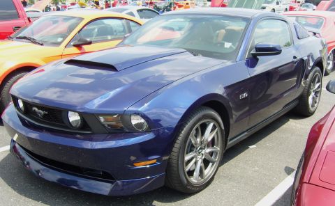 2007 Ford Mustang - A blue Ford Mustang GT is parked at an outdoor car show with other vehicles visible.
