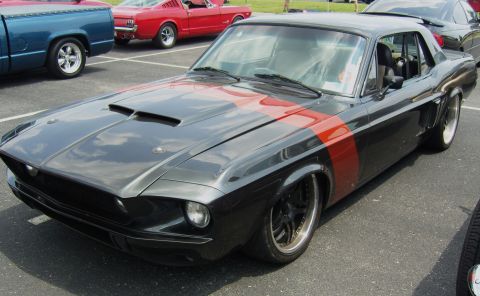 2007 Ford Mustang - Customized classic car with racing stripes parked at an outdoor event. Another classic Mustang is visible in the background.