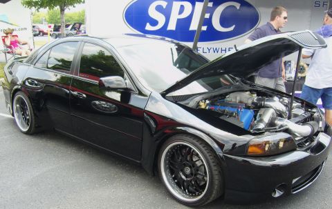 2007 Ford Mustang - A black sedan, possibly a 2004 model, is displayed with its hood open, revealing the engine and custom wheels.