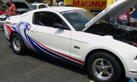 2007 Ford Mustang - A white 2007 Ford Mustang Cobra Jet is displayed with its hood open, revealing the engine compartment.