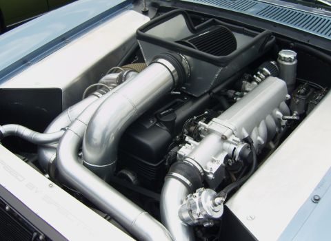 2007 Ford Mustang - custom twin-turbo engine bay featuring large polished aluminum intake piping and intercooler plumbing.