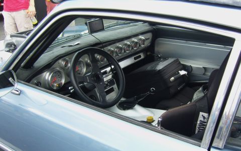 2007 Ford Mustang - The interior of a modified vehicle features a custom dashboard with numerous gauges and a racing steering wheel.