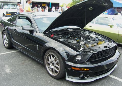 2007 Ford Mustang - A black 2007 Ford Mustang is displayed with its hood open, revealing the engine compartment.
