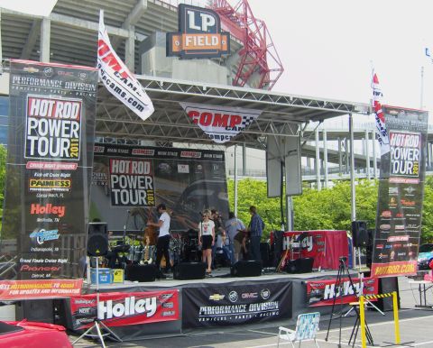 2007 Ford Mustang - A band performs on stage at the Hot Rod Power Tour 2011, with large banners and a stadium in the background.