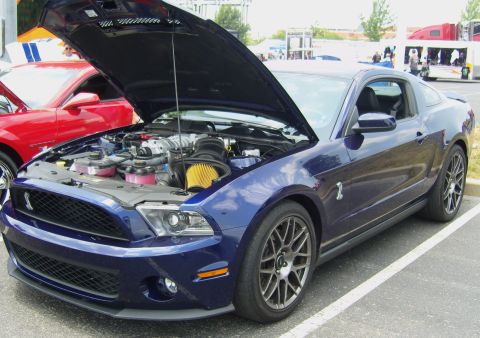 2007 Ford Mustang - A blue Ford Mustang Shelby GT500 is parked with its hood open, revealing the engine bay.
