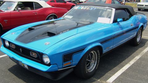 2007 Ford Mustang - A blue convertible Mustang with a black hood scoop and racing stripes is parked in a lot next to a red convertible.