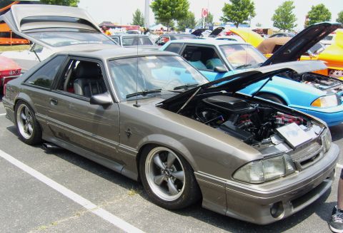 2007 Ford Mustang - A modified Ford Mustang Fox Body is displayed with its hood open at an outdoor car show.