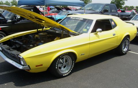 2007 Ford Mustang - A yellow 1971 Ford Mustang is parked with its hood open at an outdoor car show.