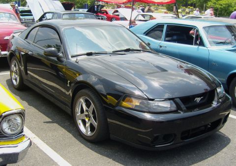 2007 Ford Mustang - A black Ford Mustang is parked at an outdoor event with other vehicles around it.