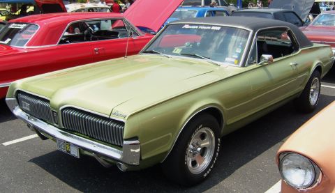 2007 Ford Mustang - A green 1967 Mercury Cougar coupe is parked at an outdoor event, with other vehicles visible.