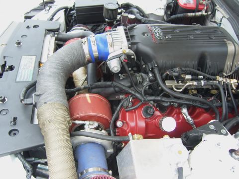 2007 Ford Mustang - Close-up of a modified Ford engine, a turbocharger and prominent Ford Racing branding on the intake manifold.