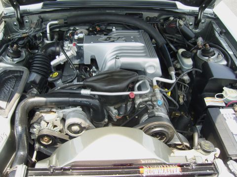 2007 Ford Mustang - Close-up view of a car's engine bay, a silver intake manifold and various hoses and components.