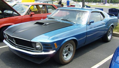 2007 Ford Mustang - A blue 1970 Ford Mustang is parked at an outdoor event, with another car visible to its left.