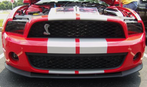 2007 Ford Mustang - Front view of a red 2007 Ford Mustang Cobra, showing the grille and open hood.