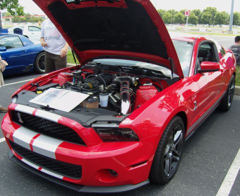 2007 Ford Mustang - A red Ford Mustang Shelby GT500 is displayed with its hood open, revealing the engine compartment.
