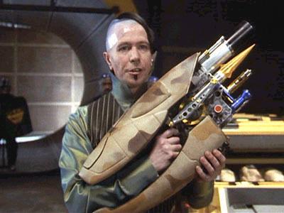 2000 Mercury Grand Marquis - A man is shown holding a complex, futuristic weapon with a camouflage pattern, possibly from a science fiction film or game.