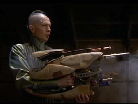 2000 Mercury Grand Marquis - A man holds a detailed, futuristic weapon with multiple barrels and intricate components.