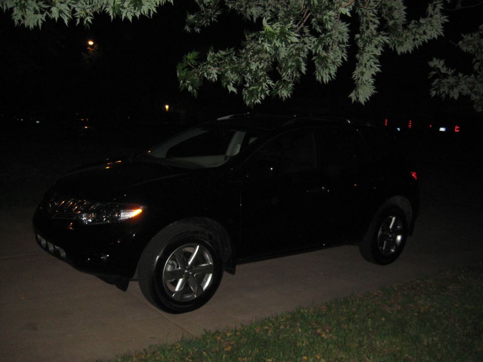 Black Nissan Murano crossover parked on a driveway at night