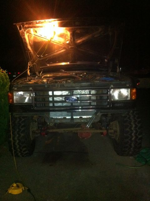 1989 Ford Bronco - Front view of a 1989 Ford Bronco with its hood open, illuminated by interior lights.