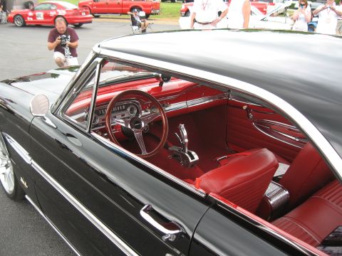 1968 Shelby GT500 - Interior view of a classic black coupe with red upholstery and a wood-rimmed steering wheel.