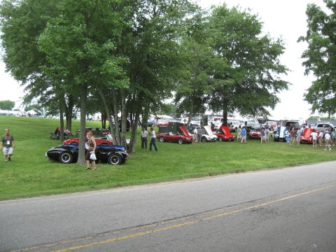 1968 Shelby GT500 - A gathering of classic automobiles on display at an outdoor event, with spectators observing the vehicles.