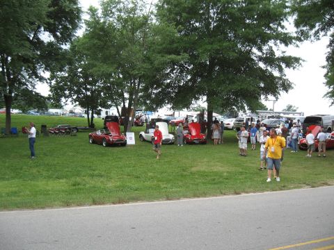 1968 Shelby GT500 - A gathering of classic cars and attendees at an outdoor event, with several vehicles parked on a grassy field.