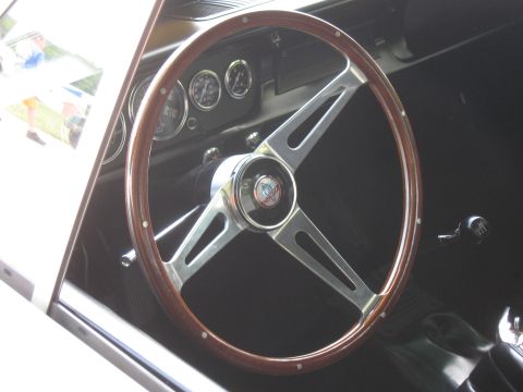 1968 Shelby GT500 - Interior view of a classic car, a wood-rimmed steering wheel and dashboard gauges.