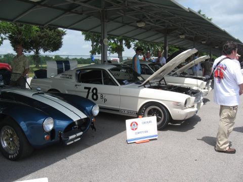 1968 Shelby GT500 - A white 1965 Ford Mustang GT350 with racing stripes and the number 78 is displayed alongside a blue Shelby Cobra at a car show.