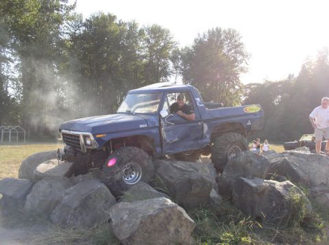 1979 Ford Bronco - This modified pickup truck is attempting to drive over a large rock formation.