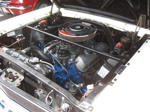 1968 Shelby GT500 - Close-up of a classic car's engine bay, with another vehicle partially visible.