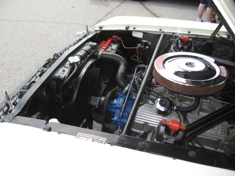 1968 Shelby GT500 - The engine bay of a classic car is shown, with the hood open, revealing the V8 engine and its components.