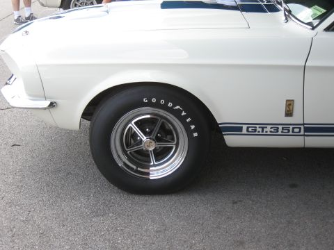 1968 Shelby GT500 - A white Shelby GT350 with blue racing stripes and a GT.350 emblem is parked on asphalt.