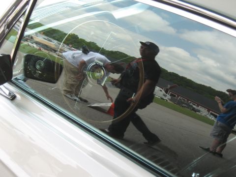 1968 Shelby GT500 - Reflection of people and a red barn in the window of a white car.