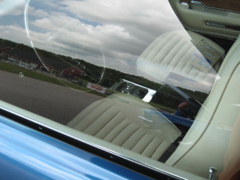 1968 Shelby GT500 - Interior view of a classic car's white seats and dashboard, with reflections on the windshield.