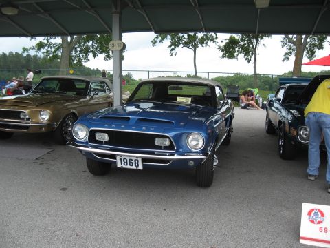 1968 Shelby GT500 - Front view of a blue 1968 Shelby GT500, part of a car show display with other vehicles.